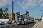 Die Straßenbahn hat soeben die Haltestelle Theater in Richtung Pafendall - Kirchberg in der Stadt Luxemburg verlassen und fährt am Monument von Robert Schumann vorbei .