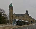 Soeben hat die straßenbahn die haltestelle „Place de Metz“ in der Stadt Luxemburg verlassen, im Hintergrund das Vewaltungsgebäude der Sparkasse.