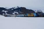 MOB Montreux - Berner Oberland - Bahn Ge 4/4 8004 zieht am 16.1.10 bunt gemischten Zug von Gstaad Richtung Gruben.