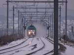 Montzenlinie Aachen-Montzen-Vise Winterimpressionen aus Ostbelgien. Cobra-Lok 2841 ist hier am Ende des Viadukts von Moresnet, auch G�hltalviadukt genannt, angelangt, w�hrend sich der Zug noch in einer Schneewolke auf dem Viadukt befindet. Im Hintergrund erkannt die verschneite Ortschaft Kelmis. Aufgenommen am 10/01/2010. 