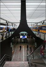 Die Stütze über dem Abgang -    Die großen Stahlstützen im Bahnhof Rotterdam Centraal gabeln sich im Bereich der Abgänge auch unten, aber um 90° gedreht, im Vergleich zu