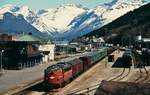 Blick auf den Bahnhof Andalsnes im Mai 1988, in der Bildmitte die Di3 619 (später Lok 005 der Kosovo Railways) vor einem beachtlichen langen Güterzug.