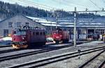 El 13.2141 und El 9.2063 Anfang Mai 1988 vor dem Lokschuppen in Geilo an der Bergenbahn, auf der Drehscheibe im Hintergrund ein Rangiertraktor der Reihe Skd 220a. Die drei Lokomotiven der Reihe 9 wurden 1944 speziell für die Flambahn gebaut und standen dort bis 1987 im Einsatz, die El 9.2063 ist heute Denkmal in Flam. El 13.2141 wurde 1961 in Dienst gestellt und 1996 abgestellt.