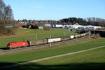 Über die Jahrzehnte hinweg hat sich diese Fotostelle bei Axdorf sehr verändert. Stand früher der Bauernhof am linken Bildrand allein auf weiter Flur, dominiert inzwischen das Traunsteiner Gewerbegebiet das Landschaftsbild. War der Streckenabschnitt zwischen Traunstein und Bergen bekannt für seine Oberleitungsmasten aus der Reichsbahnzeit, so stehen dort jetzt Masten aus Beton. Am 17. Dezember 2013 konnte hier 1016.002, mit einem gemischten Güterzug nach München Nord fahrend, eingefangen werden.