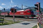 Vor dem im Hintergrund liegenden Kaisergebirge mit dem Zahmen Kaiser, Wilden Kaiser und Niederkaiser ziehen 1116 164-5 und 1144 248 einen gemischten Güterzug durch den Bahnhof von St. Johann in Tirol (27.05.2017).