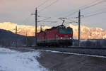 1144 200-3 mit ihrer Schwester kurz vor Sonnenaufgang bei Schlins in Richtung Bludenz. Die Bergkulisse der schweizerischen Berge hat bereits Sonne. 13.2.18