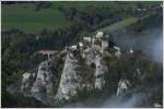Vorbei an der mit Nebelschwaden zugehllten Burg Klamm, zieht ein 1144er Tandem einen Holzzug bergwrts.