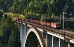 1144 059-3, 1116 088-6 und 1144 202-9 am Zugschluss, fahren auf der Pfaffenberg-Zwenberg-Brücke mit einem Güterzug den Tauern hinauf.