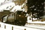 1670.21 verläßt mit dem Personenzug aus Bludenz den Arlbergtunnel in St. Anton am Arlberg. Die Aufnahme entstand Mitte der 1970er Jahre in einer Woche zwischen dem 3. und 4. Advent, als das Wetter zu schlecht zu skifahren war.