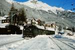 1670.105 erreicht Mitte der 1970er Jahre an einem Tag im Dezember mit dem Personenzug aus Landeck St. Anton am Arlberg. Eine 1020 wartet mit Güterzug auf die Ausfahrt Richtung Innsbruck.