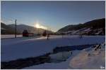 Whrend die Sonne ber der Planai untergeht, fahren 4024 102 + 4024 128 als Shuttlezug SR 9321 bei der Alpinen Ski WM 2013 in Schladming , von Schladming nach Haus im Ennstal.