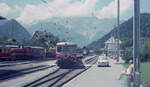 Rangierarbeit im Bf Schruns am 04.07.1974. ET10 103 der Montafonerbahn schiebt den Kurswagen Schruns - Dortmund zum Bahnsteig. Links erkennt man Lok V10 021. Scanbild 90197, KodacolorII.