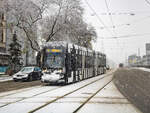 Graz. Am Vormittag des 02.12.2023 hat es in der steirischen Hauptstadt ordentlich geschneit – Variobahn 221 der Graz Linien ist hier als Linie 5 bei der Haltestelle Karlauergürtel zu sehen.