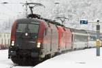 Der Railjet erreicht den Bahnhof Langen am Arlberg im dichten Schneetreiben.