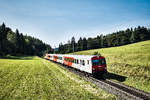 1144 241-7 schiebt die S2 4975 (Villach Hbf - Rosenbach), bei Schlatten, nahe Rosenbach vorüber.