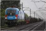 Bei strmendem Regen fhrt 1016 023  Kyoto  mit einem Gterzug in Richtung Bruck an der Mur.
Spielberg 8.8.2011