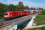 1116 143 mit Beklebung  Montan Spedition  berquert mit dem R 2225 den Donaugrben bei Bisamberg. Die Aufnahme enstand am 08.09.2013.