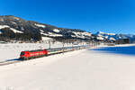 Eine knappe Sache war am 20. Januar 2024 die Aufnahme des  Snälltåget  D 305 von Malmö nach Innsbruck bei Brixen im Thale. An den kurzen Tagen im Jahr verschwindet die Sonne zur Mittagszeit nämlich für einige Zeit hinter einem Bergrücken. Wenige Minuten vor Durchfahrt des internationalen Nachtzuges lag die Fotostelle noch komplett im Schatten. So ging es sich aber glücklicherweise gut für die 193 965 mit ihren 11 Wagen aus. Darüber hinaus zeigte sich die Landschaft winterlich bei besten Wetterverhältnissen. Die Reisenden durften sich auf eine schöne Schiwoche in den österreichischen Bergen freuen. 