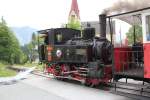 Die Zahnradlokomotive  Hermann  mit einem Personenwaggon auf der Fahrt zum Bahnhof Jenbach, hier bei Km 3,6 bei der Haltestelle Eben, Mai2014