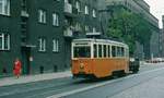 09.08.1993, Polen, Wroclaw/Breslau: Ein Arbeits-Tw fährt vorüber. Die rote Dame peppt das graue Haus ein wenig auf.