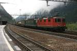 Ein Re 10/10 mit einem Guterzug fahrt ins Gotthard-tunnel ein. ...