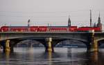 S-Bahn Dresden Vor Canaletto-Kulisse – Kurze Dosto-Einheit mit RegioDB BR143 auf Linie S2 �berquert neben der Marienbr�cke die Elbe in Ri. Dresden Hbf – Pirna (09.03.2010).