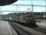 Vierertraktion BLS Re 425 durchfhrt mit einem Gterzug, vorbei an den Weinbergen und der Kirche, den Bahnhof von Spiez am 29.07.08.