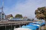 Die beiden Re 475 404 und 475 403 der BLS durchfahren mit einem Autotransportzug auf ihrem Weg entlang des Zürichsees den Bahnhof Wädenswil. Im Vordergrund liegt der kleine Bootshafen, die Anlegestelle für die Kursschiffe befindet sich aus diesem Blickwinkel auf der rechten Seite. 07.10.2016