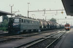 SBB/ASm: Ae 6/6 11408 SOLOTHURN vor einem Ölzug beim Passieren des Bahnhofs Niederbipp im März 1998.