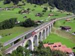 Berner Oberland 2007 - Unser erster Ausflug fhrte uns noch am Nachmittag des 12.07.2007 nach Frutigen auf die Tellenburg. Von hier aus bieten sich fantastische Blicke auf den imposanten Kanderviadukt. Hier berquert ihn ein Prchen Re 10/10, bestehend aus einer grnen Re 6/6 und einer roten Re 4/4. mit einem Autowagen-Leerpark den Viadukt auf dem Regelgleis.