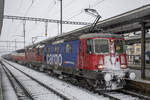 Re 4/4 II 11270 und 11326 sind bei Schneetreiben auf dem Weg in den RBL. Aufgenommen bei der Durchfahrt in Brugg AG am 10.12.2021.