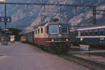 Eine der gelungensten konventionellen Elektrolok-Baureihen ist die Re 4/4 II der SBB. 
Hier steht die TEE-farbene 11249 mit einem Zug aus Einheitswagen II im Bahnhof Brig im Rhone-Tal. 
28. Juni 1988; 
Canon AE1, Canoscan, Gimp