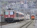 Re 4/4 II 11209 verlsst mit dem RheintalExpress Chur, whrenddem Gm 3/3 233 der RhB rangiert. Im Hintergrund ist der Martinsturm und das Quartier Klberweide zu erkennen. (09.12.2007)