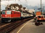 11245 Re 4/4 mit Regionalzug Interlaken-Ost-Zrich auf Bahnhof Spiez am 28-07-1995.