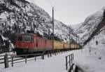 Die Re 4/4 II 11283 verlässt mit ihrem Postzug den Bahnhof Göschenen und macht sich auf den Weg Richtung Norden. Aufgenommen am 23.02.2015