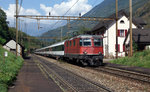 SBB: Re 4/4 11157 II vor der Kulisse des bereits seit vielen Jahren stillgelegten Bahnhofs Giornico am 13.