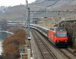 SBB Re 460 117-5 zieht einen Interregio bei St Saphorin, am Ufer des Lc Leman entlang, in Richtung Montreux am 25.02.2012.