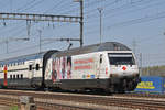 Re 460 041-7, mit der Rotkreuz Werbung, durchfährt den Bahnhof Muttenz.