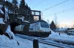 Ein nahezu perfekt getarnter Güterzug in der weissen Schnee- und Felsenlandschaft des Gotthards.