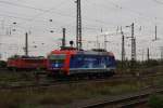 Die Werbelok 482 037-9 ``Infraleuna`` der SBB Cargo stand am 17.10.2013 im Bahnhof Grokorbetha, daneben steht eine BR 155. Im Hintergrund sieht man gut die Gasflamme der Leuna-Werke.