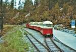 Der rotweisse Panorama-Schmalspurbahn mit offenem Verdeck, unterhalb der Staumauer des Lac d’Emosson, am 07.09.1985