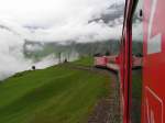 Von Ntschen her nhert sich der Zug dem Loch in der Wolkendecke, welche ber Andermatt schwebt.