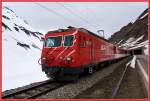 Kurz vor dem Bahnhof Oberalppasshhe kommt der Regionalzug, die HGe 4/4 106 macht nur fr den Glacier Express Werbung, aus dem Tunnel, der die Kantone Uri und Graubnden trennt.