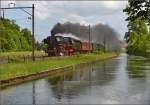 Das Wochenende am Bodensee ist beendet und der Zug mit 01 202 ist auf dem Rckweg. Bei Brglen am Thurkanal kommt sie mit deutlich vor Fahrplan mit Volldampf vorbeigerauscht. Mai 2015.