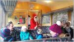 Der Nikolaus verteilt im Triebwagen 24 des Extrazuges Chlausensäckli mit Nüssen und Süssigkeiten an die Passagiere.