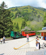 BRB-Zug für Privatanlass mit Lok 5 und B 16 rangiert in Station Planalp, während Alphorn und Handharmonika gespielt wird.