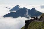 Der letzte heutige Zug wartet auf die Abfahrt Richtung Brienz. Die Bergkette dahinter, der Brienzer Rcken, ragt noch aus dem Wolkenmeer heraus. Gute Fahrt! Aufnahme in Rothorn Kulm, 02. Juni 2011, 17:40