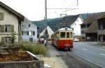 Zwischen Misthaufen und Straße ist BDe 4/4 1 oder 2 der Waldenburgerbahn im Juli 1983 in Hölstein unterwegs.