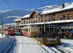 Älterer Triebwagen mit Flachwagen auf dem Weg ins Depot und ein Triebzug im Stilllager in der Station Kleine Scheidegg (2061 müM). Das Foto wurde von einem Wegübergang aus gemacht. Kleine Scheidegg, 11.1.2024