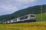 Montreux - Oberland bernois MOB.
Erinnerung an die alte MOB.
Noch nicht verpendelter, stilreiner  PANORAMIC-EXPRESS  mit GDe 4/4 6003  Saanen  zwischen Les Combes und Rougemont im Juni 1992.
Foto: Walter Ruetsch 
